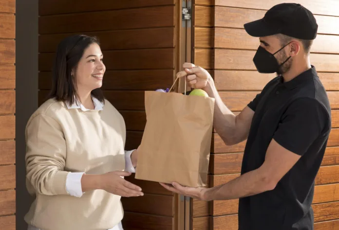 mulher-recebendo-uma-sacola-de-comida-2048x1392 Cobrança mínima no delivery? Procon SC diz que é proibido