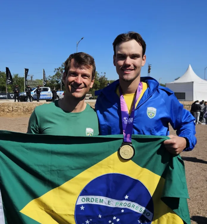 O atleta Daniel Passold Filho, do Clube Náutico América/SME Blumenau, conquistou neste domingo, dia 10, a primeira medalha de ouro do Brasil nos Jogos Pan-Americanos Júnior 2025, disputados em Assunção, no Paraguai. O título veio em parceria com o remador João Batista na final do double skiff masculino. A dupla brasileira liderou a prova de ponta a ponta e fechou com o tempo de 6min31s. Daniel também conquistou a medalha de prata na prova oito com timoneiro, juntamente com o timoneiro Marcello Oliveira e os atletas Andrei Alves, Arthur Aguiar, Diogo Gonçalves, João Batista, Kayki Siqueira, Marcelo de Almeida e Miguel Marques. O atleta de Blumenau ainda buscará uma terceira medalha, na prova do four skiff. Outra representante do Clube Náutico América/SME Blumenau na competição, Giulia Alves foi quinta colocada na prova quatro sem timoneiro, juntamente com as atletas Ana Ferreira, Luiza Nazario e Maria Fuhrmann. Ela ainda terá chance de medalha na disputa da prova oito com timoneiro. Além de Daniel e Giulia, o treinador Roque Zimmermann também representa Blumenau na competição continental. Brasil nos Jogos O Brasil lidera o quadro de medalhas dos Jogos Pan-Americanos Júnior, com 22 medalhas conquistadas, sendo 11 de ouro, cinco de prata e seis de bronze. O Chile aparece na segunda colocação, com 11 medalhas (seis ouros, três pratas e dois bronzes), seguido pela Colômbia, com dez medalhas (dois ouros, duas pratas e seis bronzes). O Brasil busca o bicampeonato dos Jogos. Na primeira edição da competição, disputada em Cali (Colômbia), o país ficou na primeira colocação com 164 medalhas no total, sendo 59 de ouro, 49 de prata e 56 de bronze.